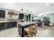 Open-concept kitchen with black cabinets, stainless appliances, island with seating, and stylish lighting at 7461 Pescador Pl, Seminole, FL 33772