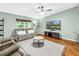 Inviting living area showcasing hardwood floors, a ceiling fan, and a mounted television at 7461 Pescador Pl, Seminole, FL 33772