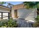 A view of the backyard shed featuring a neutral door surrounded by lush tropical landscaping at 7461 Pescador Pl, Seminole, FL 33772