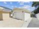 Detached garage featuring a clean exterior, a side door, and a paved driveway at 807 Illinois Ave, Palm Harbor, FL 34683