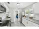 Galley kitchen with stainless steel appliances, granite countertops, white cabinetry, and tiled backsplash at 807 Illinois Ave, Palm Harbor, FL 34683