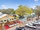 Overhead view of restaurants with inviting outdoor seating, set amongst lush trees and vibrant greenery at 807 Illinois Ave, Palm Harbor, FL 34683