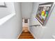 View looking down wooden stairs with white walls and framed art on the side at 8415 Edgewater Place Blvd, Tampa, FL 33615