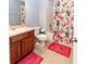 Bright bathroom featuring a single sink vanity, tile flooring, and a shower with colorful curtain at 8568 Sandy Beach St, Tampa, FL 33634
