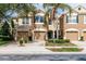 Inviting townhome featuring a well-manicured lawn, two-car garage, and lush landscaping at 8568 Sandy Beach St, Tampa, FL 33634