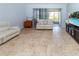 Bright living room with tile floors and a view to screened lanai and pool at 8568 Sandy Beach St, Tampa, FL 33634