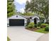 Charming exterior with black garage door, red front door and manicured front yard at 9191 64Th N Way, Pinellas Park, FL 33782