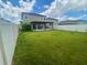 Large backyard featuring a lush lawn, patio area with pergola, and fenced perimeter at 9520 Lemon Drop Loop, Sun City Center, FL 33573
