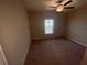 Cozy bedroom with neutral carpet, a ceiling fan, and a bright window providing natural light at 9520 Lemon Drop Loop, Sun City Center, FL 33573