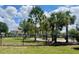 Fenced dog park in the community with mature trees and green grass at 9520 Lemon Drop Loop, Sun City Center, FL 33573