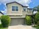 Two-story home featuring an attached two-car garage and well-maintained landscaping at 9520 Lemon Drop Loop, Sun City Center, FL 33573