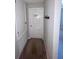 Hallway area with carpet, a door to the laundry room, and hooks for hanging items at 9520 Lemon Drop Loop, Sun City Center, FL 33573