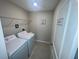 Functional laundry room equipped with washer, dryer, and storage shelving at 9520 Lemon Drop Loop, Sun City Center, FL 33573