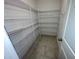 Walk-in pantry with multiple shelves for storage and tile flooring at 9520 Lemon Drop Loop, Sun City Center, FL 33573