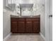 Bathroom showcasing dual sinks with granite counters and dark wood cabinets at 9605 Channing Hill Dr, Sun City Center, FL 33573