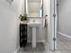 Half bathroom with a pedestal sink, decorative accents, and a modern mirror at 9605 Channing Hill Dr, Sun City Center, FL 33573