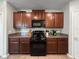 Kitchen with dark wood cabinets, stainless steel appliances and tile floors at 9605 Channing Hill Dr, Sun City Center, FL 33573