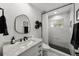 A modern bathroom features black hardware, a marble countertop, decorative shelves, and black and white tile at 10516 Gretna Green Dr, Tampa, FL 33626