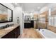 Bathroom featuring dual sinks, granite countertops, bathtub and walk in shower at 10516 Gretna Green Dr, Tampa, FL 33626