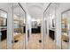 Hallway featuring closets with mirrored doors and access to the main bathroom with soaking tub at 10516 Gretna Green Dr, Tampa, FL 33626