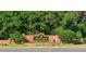 Welcoming community entrance sign, framed by lush trees and colorful flowers at 10516 Gretna Green Dr, Tampa, FL 33626