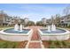 Community fountain with brick-paved walkway and benches, surrounded by townhomes at 10516 Gretna Green Dr, Tampa, FL 33626