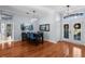 Dining room featuring hardwood floors, modern chandelier, bright blue chairs, and view of backyard at 10516 Gretna Green Dr, Tampa, FL 33626