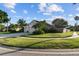 Traditional home featuring a manicured lawn, lush tropical plants, and a spacious three-car garage at 10516 Gretna Green Dr, Tampa, FL 33626