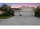 Home featuring a 3-car garage and lush landscaping with concrete driveway at 10516 Gretna Green Dr, Tampa, FL 33626