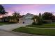 Home featuring a 3-car garage and lush landscaping, captured at dusk at 10516 Gretna Green Dr, Tampa, FL 33626