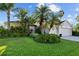 Charming home boasts lush landscaping, vibrant green lawn, and stately palm trees at 10516 Gretna Green Dr, Tampa, FL 33626