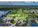 Aerial view of a golf course with lush fairways and water features surrounded by beautiful homes and nature at 10516 Gretna Green Dr, Tampa, FL 33626