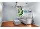 Cozy living room featuring hardwood floors, a gray sofa, and a large window at 10516 Gretna Green Dr, Tampa, FL 33626