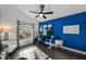 A blue accent wall with a window that has a desk, lamp, chair and decorations at 10516 Gretna Green Dr, Tampa, FL 33626