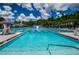 Bright community pool featuring lap lanes, a lifeguard stand, and ample seating surrounded by mature trees at 10516 Gretna Green Dr, Tampa, FL 33626