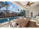 View of pool with a covered patio, an outdoor table and chairs, and beautiful backyard landscaping at 10516 Gretna Green Dr, Tampa, FL 33626