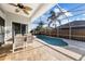 Relaxing view of a screened in pool and outdoor patio with table and chairs at 10516 Gretna Green Dr, Tampa, FL 33626