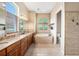 Bright bathroom with double sinks, soaking tub, tiled shower, and neutral color palette at 10645 Ruffino Ct, Trinity, FL 34655