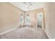 Cozy bedroom with soft carpet, ceiling fan, and bench seating beneath large windows at 10645 Ruffino Ct, Trinity, FL 34655