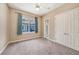 This bright bedroom features a ceiling fan, soft carpet, and an ensuite bathroom at 10645 Ruffino Ct, Trinity, FL 34655