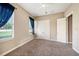 Neutral bedroom featuring a ceiling fan, carpet, and natural light from window with blinds at 10645 Ruffino Ct, Trinity, FL 34655