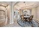 Open-concept dining room with tile floors, a decorative rug, and a chandelier creates an elegant dining space at 10645 Ruffino Ct, Trinity, FL 34655