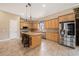 Kitchen with granite countertops, light wood cabinets, stainless steel appliances and seating at the kitchen island at 10645 Ruffino Ct, Trinity, FL 34655