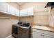 Laundry room with washer, dryer, utility sink, and white cabinets for storage at 10645 Ruffino Ct, Trinity, FL 34655