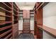 Custom walk-in closet offers ample storage with wooden shelving and drawers at 10645 Ruffino Ct, Trinity, FL 34655