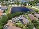 Aerial view showcasing the home, pool, fenced yard, solar panels, and scenic water views at 10709 Rockledge View Dr, Riverview, FL 33579