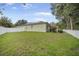 Well-maintained backyard featuring a white fence, lush lawn, and solar panels for energy efficiency at 10709 Rockledge View Dr, Riverview, FL 33579