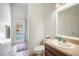 Bright bathroom with a single vanity, toilet, shower with access to the screened pool area at 10709 Rockledge View Dr, Riverview, FL 33579