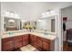 Spacious bathroom with double sinks, brown cabinets, large mirrors and neutral countertops at 10709 Rockledge View Dr, Riverview, FL 33579