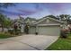 Charming single-Gathering home with a three-car garage, green lawn, and colorful landscaping at 10709 Rockledge View Dr, Riverview, FL 33579